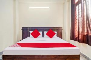 - une chambre avec un lit et des oreillers rouges dans l'établissement Flagship Hotel Moonshine Inn, à New Delhi