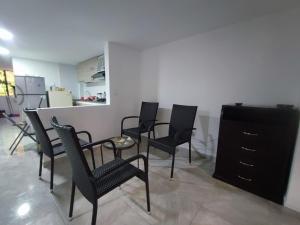 a room with chairs and a table and a kitchen at Ninfa del Mar Hostal in Manizales