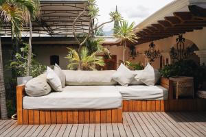 a couch sitting on a porch with pillows on it at Los Pilares Hotel in Oaxaca City