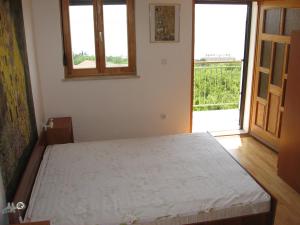 a bedroom with a bed and a large window at Apartments Sopaljska 24a in Crikvenica