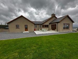 una casa con un césped verde delante de ella en Montana, en Castlewellan