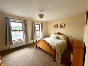 1 dormitorio con 1 cama de madera y 2 ventanas en Montana, en Castlewellan