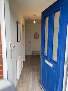 Una puerta azul en una habitación con pasillo en The Arrows Bungalow en Waddington