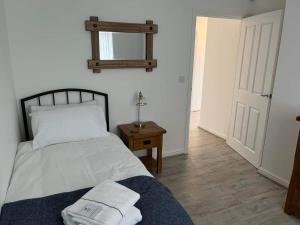 1 dormitorio con 1 cama con 2 toallas en The Arrows Bungalow en Waddington