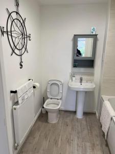 a bathroom with a white toilet and a sink at The Arrows Bungalow in Waddington