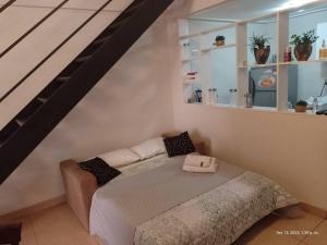 een slaapkamer met een bed en een trap bij Loft Plaza Belgrano in San Miguel de Tucumán