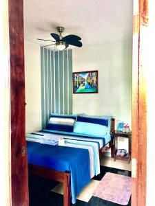 a bedroom with a blue bed and a ceiling fan at Hidden Garden Pensione in El Nido +4 photos