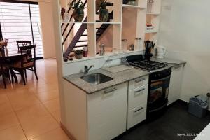 una cucina con lavandino e piano cottura di Loft Plaza Belgrano a San Miguel de Tucumán