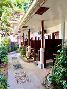 a courtyard of a building with trees and plants at Hidden Garden Pensione in El Nido