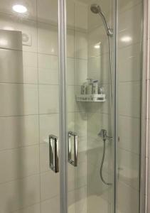 baño con ducha y puerta de cristal en Departamento Excelente Ubicación en Concepción