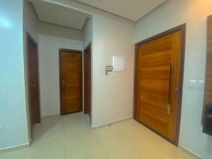 um corredor com duas portas de madeira num edifício em Casa no Condomínio Jardim Europa em Macapá