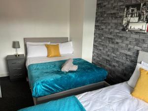 1 dormitorio con 2 camas y pared de ladrillo en WV1 Bridge House - 3 Bedrooms, sleeps 6 free Parking - New Cross - Bentley Bridge - 欢迎, en Wolverhampton