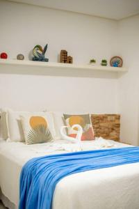 a white bed with a blue blanket on top of it at Flat na natureza in Bonito