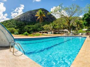 a swimming pool with a mountain in the background at Flat na natureza in Bonito