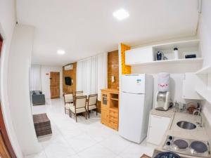 a kitchen with a white refrigerator and a table at Flat na natureza in Bonito