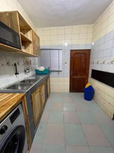 cocina con fregadero y lavadora en Entrée personnelle 2 chambres, en Cotonou