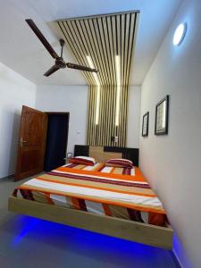 1 cama en un dormitorio con ventilador de techo en Entrée personnelle 2 chambres, en Cotonou