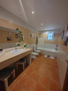 ein Badezimmer mit einer Badewanne, einem Waschbecken und einem WC in der Unterkunft Bed&Breakfast Las Salinas House Private Rooms in Ses Salines