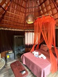 a bedroom with a bed with an orange mosquito net at Casa Tropical Playa Grande in Cuajiniquil +61 photos
