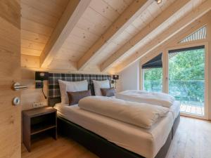 a bedroom with a large bed and a large window at Schmittenblick 5 in Viehhofen