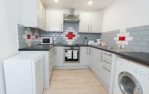 cocina con armarios blancos y lavadora en Modern Apartment in Liverpool City Centre, en Liverpool