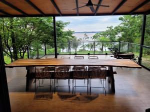 un grande tavolo in legno con sedie su un patio di Casa sobre el río a Posadas