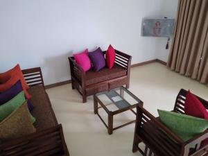 a living room with two couches and a coffee table at Cosy Holiday Home in Jayarajapuraya