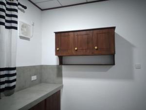 a kitchen with a wooden cabinet in a room at Cosy Holiday Home in Jayarajapuraya