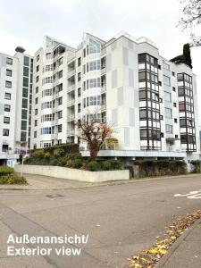 eine leere Straße mit einem großen Apartmenthaus in der Unterkunft Wohnen mit Panoramablick in Kornwestheim