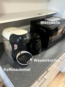 a microwave and a coffee maker on a kitchen counter at Wohnen mit Panoramablick in Kornwestheim