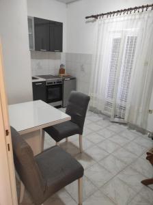 cocina con mesa, 2 sillas y fogones en Apartments by the sea Vis - 2457, en Vis