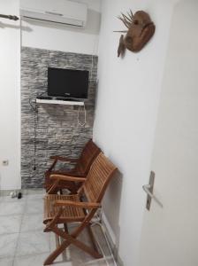 ein Wohnzimmer mit 2 Stühlen und einem TV in der Unterkunft Apartments by the sea Vis - 2457 in Vis