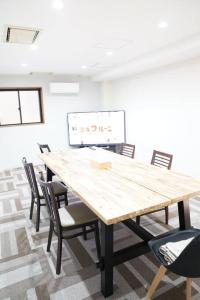 uma sala de conferências com uma mesa de madeira e cadeiras em 心斎橋USJ155m2 Party OK JR駅徒歩1分 em Osaka