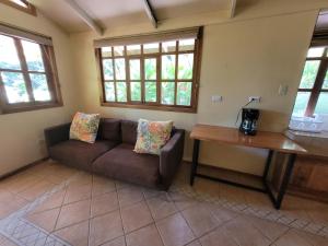 een woonkamer met een bank en een tafel bij Cabina Rancho la Merced in Uvita