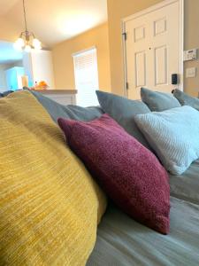 a pile of pillows sitting on top of a bed at Cheerful 3 Bdrm space, 2 bath!. You gotta love it! in Oklahoma City