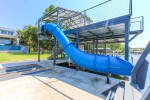 a blue water slide in a park with at Luxury Lake LBJ House with Heated Swimming Pool and Spill Over Hot Tub and 2 Boat Slips in Kingsland
