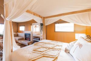 ein Schlafzimmer mit einem Himmelbett und ein Wohnzimmer in der Unterkunft NRMA Phillip Island Beachfront Holiday Park in Cowes