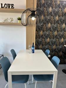 a white table with chairs and a bottle of water on it at Bilbao House in Adeje