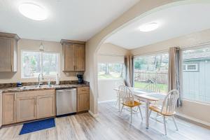 a kitchen with a table and chairs next to a window at Little Wygant Road Retreat in Coos Bay +15 photos
