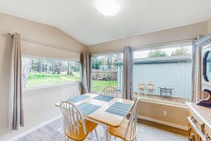 a dining room with a table and chairs and a window at Little Wygant Road Retreat in Coos Bay