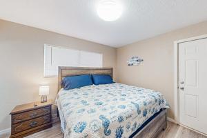 um quarto com uma cama com almofadas azuis e uma mesa em Little Wygant Road Retreat em Coos Bay