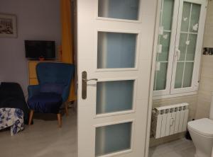 een deur naar een badkamer met een stoel en een toilet bij Apartamento Gallarza !!! PARKING PRIVADO GRATUITO!! in Logroño