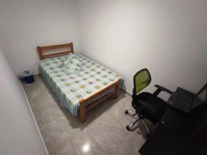 a bedroom with a bed and a desk and a chair at Hostal Ninfa del Mar in Manizales