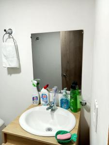 y baño con lavabo y espejo. en Hostal Ninfa del Mar, en Manizales