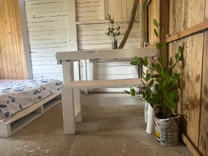um banco branco num quarto com uma cama em Nature Harmony Retreat in Tierra Bomba - Your Sustainable Escape 01 em Cartagena das Índias
