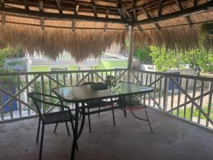 een tafel en stoelen op een balkon met een rieten dak bij Nature Harmony Retreat in Tierra Bomba - Your Sustainable Escape 01 in Cartagena