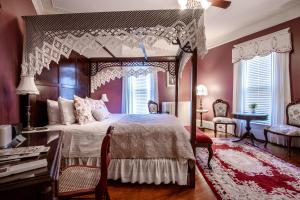 a bedroom with a canopy bed and a table and chairs at The Oaks Victorian Inn in Christiansburg
