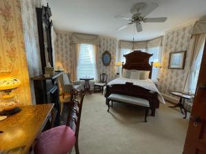 um quarto com uma cama e cadeiras num quarto em The Oaks Victorian Inn em Christiansburg