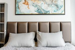a bed with two pillows and a painting above it at 1 BR plus@42th FL /2-3 min walk to BTS MRT Ladprao in Bangkok +30 photos