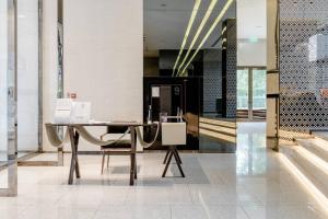 a table in a lobby with a desk and chairs at 1 BR plus@42th FL /2-3 min walk to BTS MRT Ladprao in Bangkok